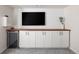 Basement featuring custom cabinets, wood countertops, a small refrigerator, and a TV at 13777 W Amherst Way, Lakewood, CO 80228