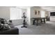 Basement space with an exercise bike, shuffleboard table, and cozy couch at 13777 W Amherst Way, Lakewood, CO 80228