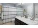 Bright bathroom featuring a double sink vanity and a shower with a decorative striped curtain at 13777 W Amherst Way, Lakewood, CO 80228