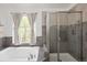 Bathroom boasting a soaking tub, neutral tiling, and a glass-door shower at 13777 W Amherst Way, Lakewood, CO 80228