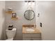 Bathroom boasts natural wood shelving, a round mirror, and granite sink countertop at 13777 W Amherst Way, Lakewood, CO 80228