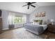 Bright primary bedroom features a ceiling fan, window, and a comfortable king bed at 13777 W Amherst Way, Lakewood, CO 80228