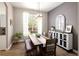 Bright dining room features a rustic wood table, bench seating, chandelier, and a large window view at 13777 W Amherst Way, Lakewood, CO 80228