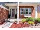 Inviting front porch with a cozy swing, red brick accents, and beautiful landscaping at 13777 W Amherst Way, Lakewood, CO 80228