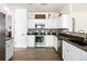 Well-lit kitchen with white cabinetry, stainless steel appliances, and tiled backsplash at 13777 W Amherst Way, Lakewood, CO 80228