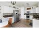 Bright kitchen with white cabinets, stainless steel appliances, granite countertops, and wood-style flooring at 13777 W Amherst Way, Lakewood, CO 80228