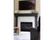 Living room features a dark wood fireplace, white tile, and a mounted television at 13777 W Amherst Way, Lakewood, CO 80228