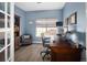 Comfortable home office with wood floors, blue walls, and a large window with natural light at 13777 W Amherst Way, Lakewood, CO 80228