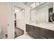 Modern bathroom features a walk-in closet, marble tile, grey vanity, and large mirror at 427 Milwaukee St, Denver, CO 80206