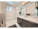 Modern bathroom featuring white marble tile, glass shower, gray vanity and a large mirror at 427 Milwaukee St, Denver, CO 80206