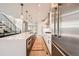 Open concept kitchen with a large island, white cabinets, stainless steel appliances, and modern pendant lighting at 427 Milwaukee St, Denver, CO 80206