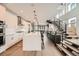 Modern kitchen with white cabinetry, stainless steel appliances, a large island, and eye-catching iron with wood staircase at 427 Milwaukee St, Denver, CO 80206