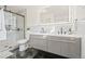 Stylish bathroom showcasing a glass shower, toilet, double vanity with modern fixtures, and LED mirror at 2713 S Hazel Ct, Denver, CO 80236