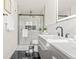 Bright bathroom with a glass shower, toilet, double vanity with modern fixtures, and sleek finishes at 2713 S Hazel Ct, Denver, CO 80236