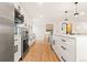 The kitchen features bright countertops, modern appliances and hardwood floors at 2713 S Hazel Ct, Denver, CO 80236