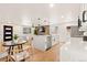 Open-concept kitchen and living space with a large kitchen island and seating at 2713 S Hazel Ct, Denver, CO 80236