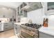Close-up on the kitchen showing a professional stove, stainless vent hood and decorative backsplash at 5420 Baseline Rd, Boulder, CO 80303
