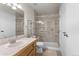 Bright bathroom featuring a glass shower, tile floor, white cabinets, and ample vanity space at 23 Shetland Ct, Highlands Ranch, CO 80130