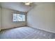 Bedroom with a large window with views of the surrounding neighborhood and a ceiling fan at 930 Button Rock Dr # 29, Longmont, CO 80504