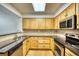Kitchen with wood cabinets, stainless steel appliances, and tile backsplash at 930 Button Rock Dr # 29, Longmont, CO 80504