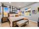 Stylish bedroom featuring a bed with decorative pillows, an accent wall, and natural light from two windows at 19495 W 94Th Ave, Arvada, CO 80007