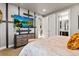 Contemporary bedroom featuring a TV, neutral walls, and a view into the bathroom at 19495 W 94Th Ave, Arvada, CO 80007