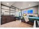 Comfortable bedroom with modern decor, dark wood furniture, and two large windows showcasing the beautiful outdoor view at 19495 W 94Th Ave, Arvada, CO 80007