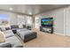 Spacious living room featuring a gray sectional sofa, a TV, and an open layout at 19495 W 94Th Ave, Arvada, CO 80007
