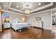 Bright main bedroom featuring hardwood floors, tray ceiling, and elegant furnishings at 19495 W 94Th Ave, Arvada, CO 80007