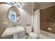 Charming bathroom features a pedestal sink, tiled shower and bath, and classic fixtures, offering a functional and stylish space at 5364 Dunraven Cir, Golden, CO 80403