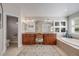 Bright bathroom featuring a double vanity, soaking tub under windows, and a water closet at 5364 Dunraven Cir, Golden, CO 80403