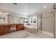 Bright bathroom featuring a double vanity, soaking tub under windows, and a glass-enclosed shower at 5364 Dunraven Cir, Golden, CO 80403