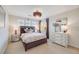 Cozy bedroom with a plush bed, modern chandelier, and a view of the hillside through sheer curtains at 5364 Dunraven Cir, Golden, CO 80403
