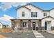 Charming two-story home featuring stone accents, white siding, and a welcoming blue front door at 5788 N Killarney Way, Aurora, CO 80019