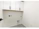 Well lit laundry room featuring white cabinets, tile flooring, and utility connections at 5788 N Killarney Way, Aurora, CO 80019