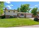 Charming two-story home with a well-manicured lawn, brick accents, and an attached two-car garage at 6143 S Ash E Cir, Centennial, CO 80121