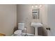Compact powder room features a pedestal sink and toilet at 6143 S Ash E Cir, Centennial, CO 80121