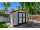 Well-maintained storage shed in backyard with double doors and gravel surroundings at 6143 S Ash E Cir, Centennial, CO 80121