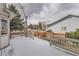 This back deck is covered in snow and features wooden rails and a partial view of the backyard and neighborhood at 23709 Glenmoor Dr, Parker, CO 80138