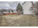 The backyard of the home features dormant grass, a wooden fence, and a view of neighboring homes at 23709 Glenmoor Dr, Parker, CO 80138