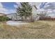 The grassy backyard features some snow cover, a patio area, and views of the neighborhood homes at 23709 Glenmoor Dr, Parker, CO 80138