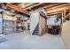 This partially finished basement features an exposed ceiling with visible ductwork and a seating area with a leather chair at 23709 Glenmoor Dr, Parker, CO 80138