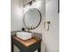 Stylish powder room with wood countertop, black accents, patterned tile backsplash, and modern sink at 23709 Glenmoor Dr, Parker, CO 80138