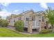 Lovely backyard showcasing a patio with stone pillars and white railings, surrounded by beautiful landscaping and green grass at 22312 E Plymouth Cir, Aurora, CO 80016