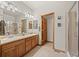 Bathroom with dual sinks, wood cabinets, and a glass-enclosed shower with tile surround at 22312 E Plymouth Cir, Aurora, CO 80016