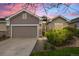 Charming home featuring a two-car garage, stone accents and manicured landscaping at sunset at 22312 E Plymouth Cir, Aurora, CO 80016