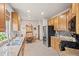 Bright kitchen with granite counters, black appliances, tile backsplash, and eat-in dining area at 22312 E Plymouth Cir, Aurora, CO 80016