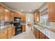 Charming kitchen with tile floors, stainless steel sink, granite counters, and black appliances at 22312 E Plymouth Cir, Aurora, CO 80016