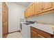 Convenient laundry room with washer, dryer, utility sink and ample cabinet storage at 22312 E Plymouth Cir, Aurora, CO 80016