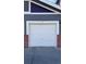 Attached one-car garage featuring a white door on a home with gray siding and red brick accents at 14221 E 1St Dr # 304, Aurora, CO 80011